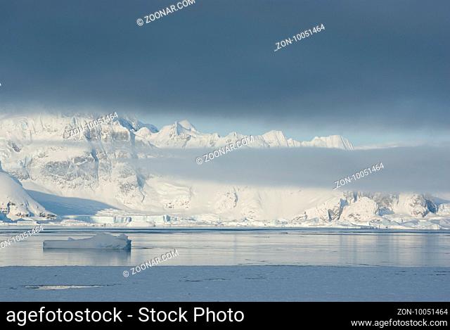 mountains of the Antarctic Peninsula covered with stratus clouds and icebergs Coast downtrodden