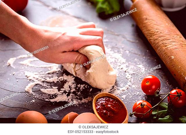 Young girl's hand knead the dough