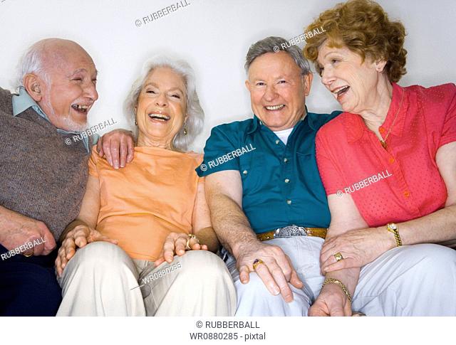 Portrait of two senior couples sitting together smiling