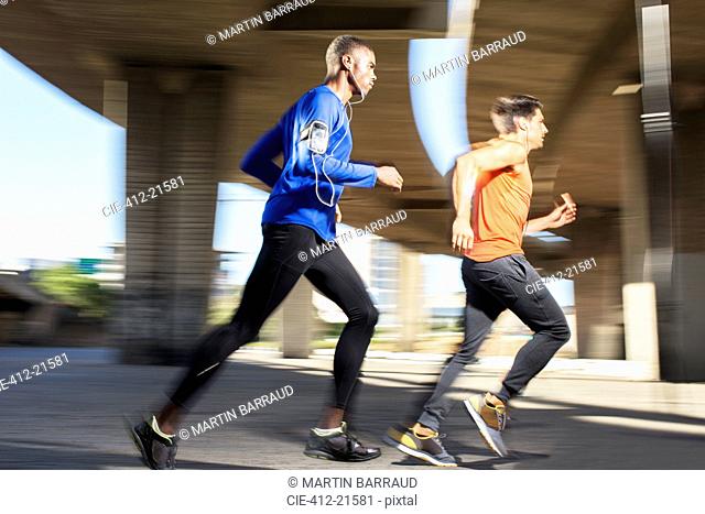 Men running through city streets together