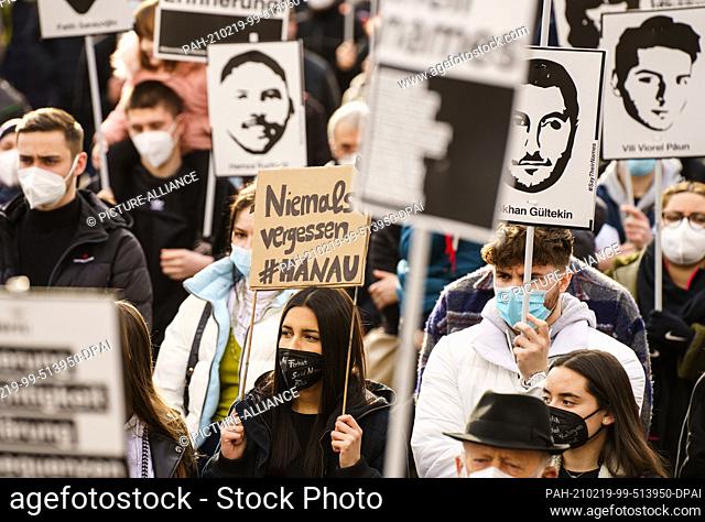 dpatop - 19 February 2021, Hessen, Hanau: A participant holds a poster ""never forget#Hanau"" at the rally commemorating the racist attack one year ago in Hanau