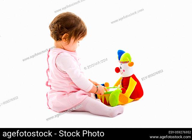 Happy baby girl sitting on floor playing with toy smiling, cotout on white background