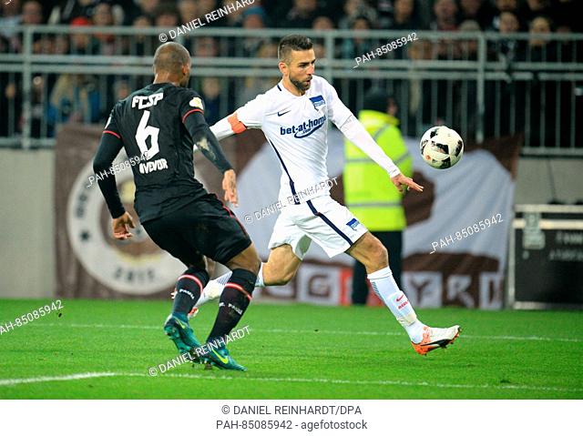 Pauli's Christopher Avevor and Berlin's Vedad Ibisevic (R) fight for the ball during the German DFB-Cup soccer match between FC St