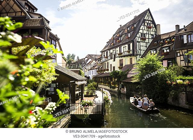 Tourists boat along channel at Little Venice in medieval town of Colmar, Alsace (department of Haut-Rhin, region of Grand Est, France)