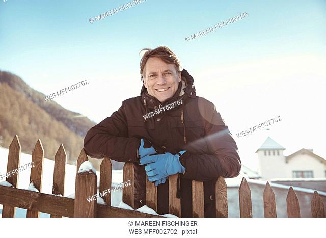 Italy, Val Venosta, Slingia, portrait of smiling mature man standing at fence