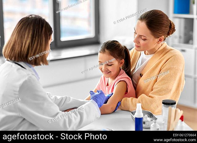 mother vaccinating her little daughter at clinic