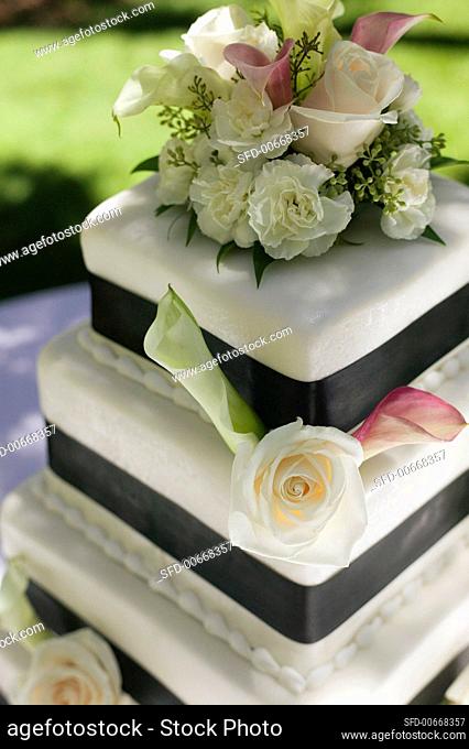 Three Tiered Wedding Cake Decorated with Roses and Calla Lilies