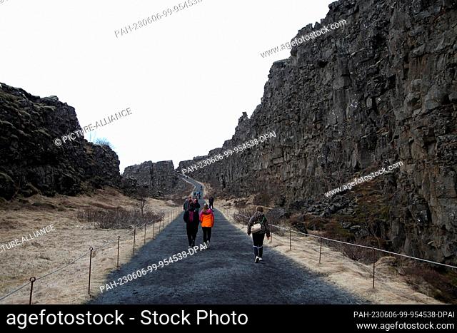 FILED - 15 April 2023, Iceland, Thingvellir: Tourists walk along the Thingvellir (Îingvellir). Near the gorge, the first popular assemblies were held in the...