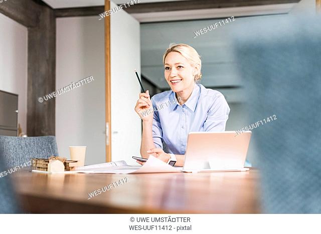 Smiling businesswoman working at desk in office