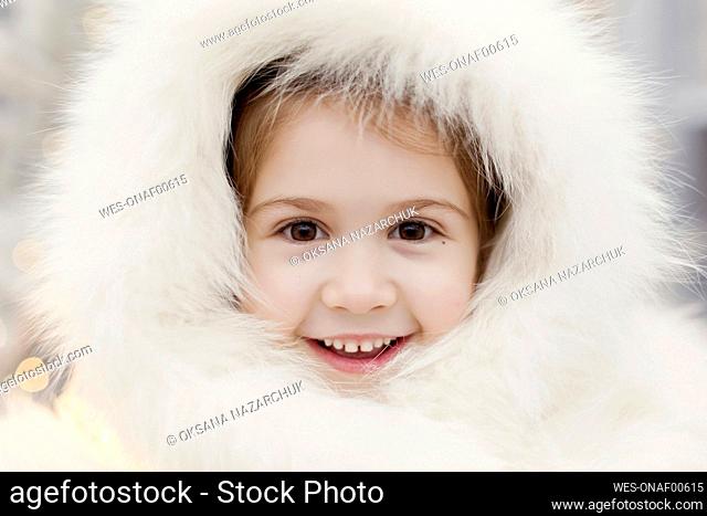 Smiling girl wearing white colored fur hat