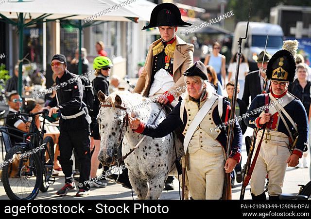 08 September 2021, Thuringia, Jena: Student Oliver Bettels dressed as Napoleon riding a horse with French and Prussian soldiers through the city center at a...