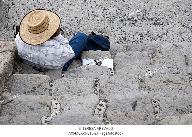 Mexican man sitting on steps near the Teotihuacan pyramids, Mexico