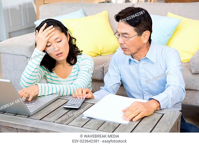 Worried couple checking bills