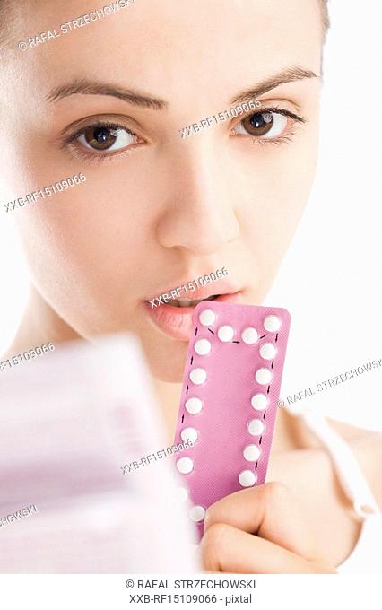 young woman holding contraceptive pills