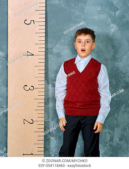 Schoolboy next to the measuring ruler, vintage concept