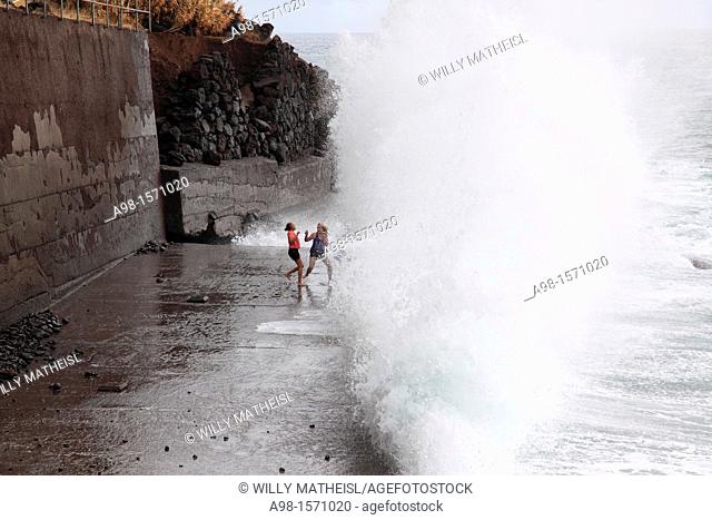 girls playing at the beach and have fun with the spray of waves, Madeira, Portugal, Europe