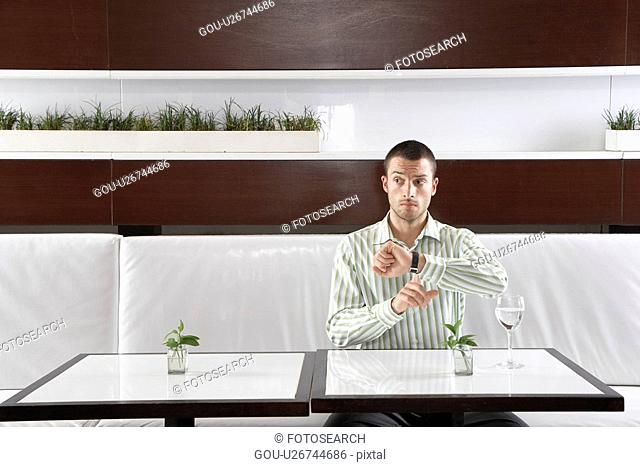 Businessman checking time in restaurant