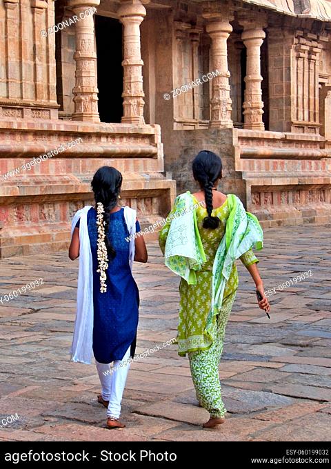 Two young women, jasmine in hair in temple, Tamil Nadu, southern India. High quality photo