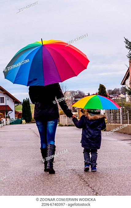 Mutter und Kind mit Regenschirm, Symbol für Solidarität, Hilfe, Hilfspaket, Rettungsschirm