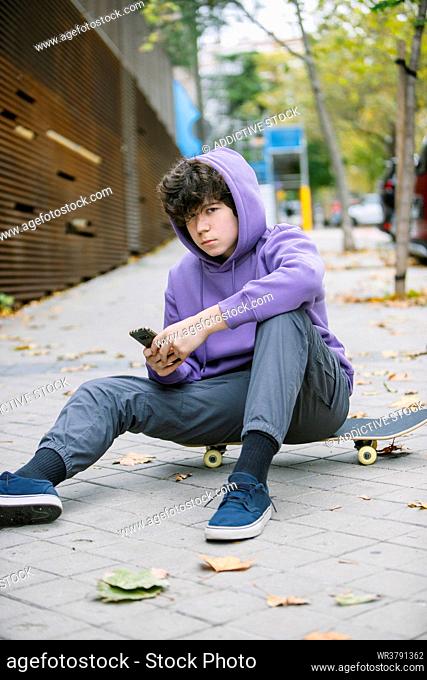 teenager, sitting, smart phone, skateboarder