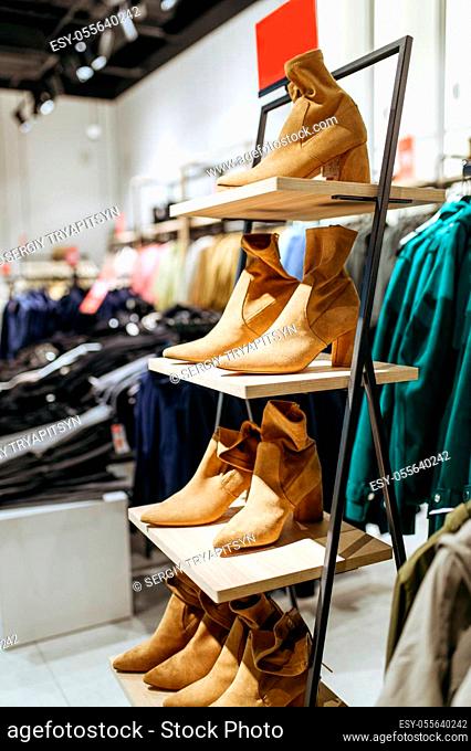 Clothes, shoes collection on shelf in clothing store, nobody. Fashion shop or boutique interior, garment in showroom