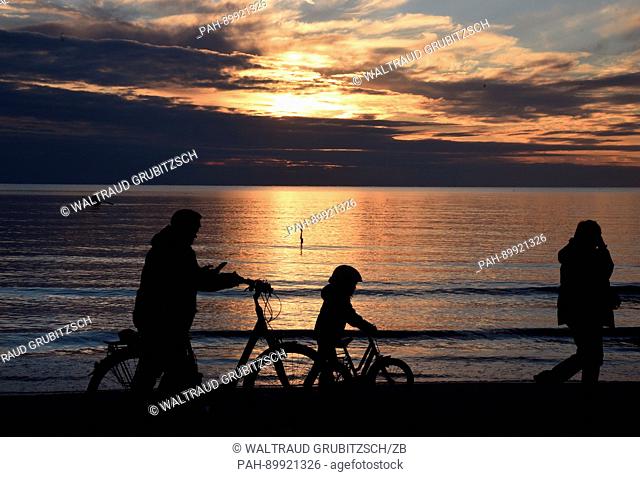 Cyclists at sunset on Sunday evening at the Baltic Sea near the town of Vitte, on the island of Hiddensee in Germany, 16 April 2017