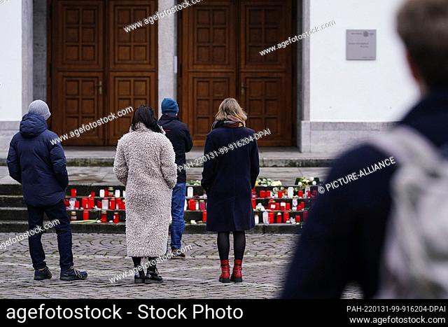 31 January 2022, Baden-Wuerttemberg, Heidelberg: People stand in front of the main entrance of the New University for a minute's silence