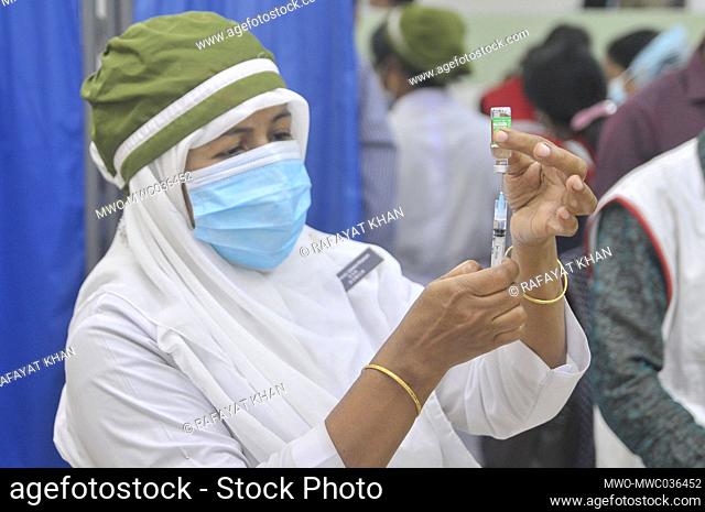 Health workers vaccinating people during the first-stage of the coronavirus vaccination program at Osmani Medical College and Hospital