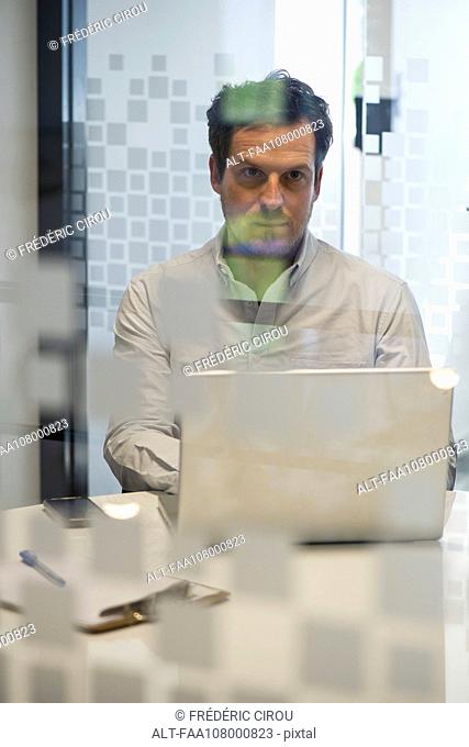 Man in office using laptop computer