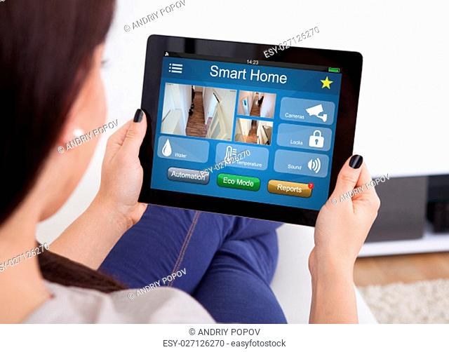Cropped image of young woman using tablet for video conference at home
