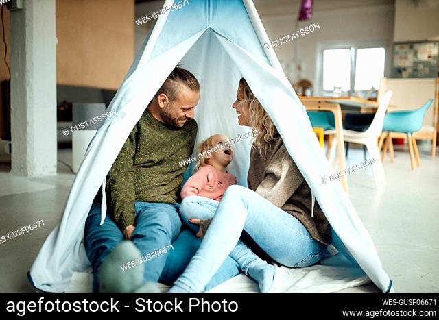Family sitting together in tent at home