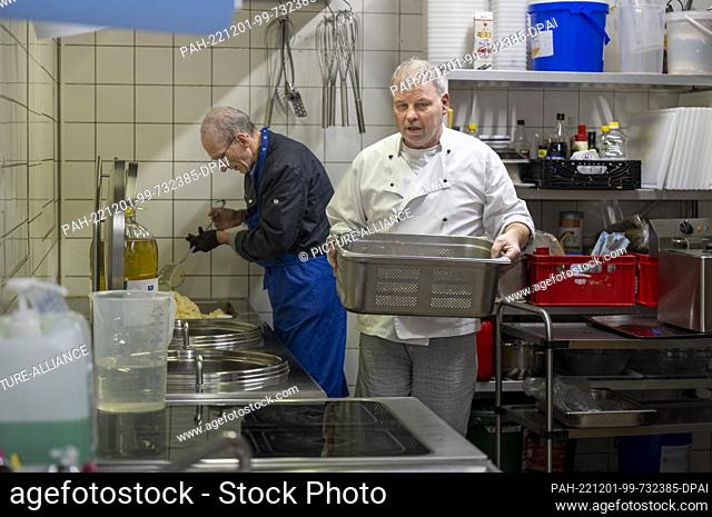 PRODUCTION - 28 November 2022, Berlin: Employees of the Berliner Stadtmission prepare a hot meal for homeless and needy people in the kitchen