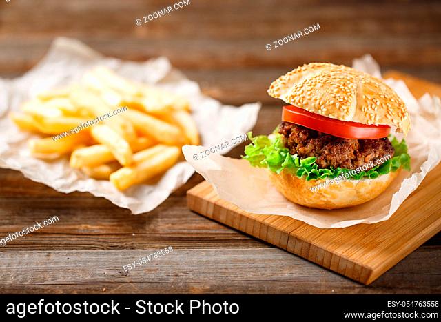 Homemade hamburgers and french fries on wooden table