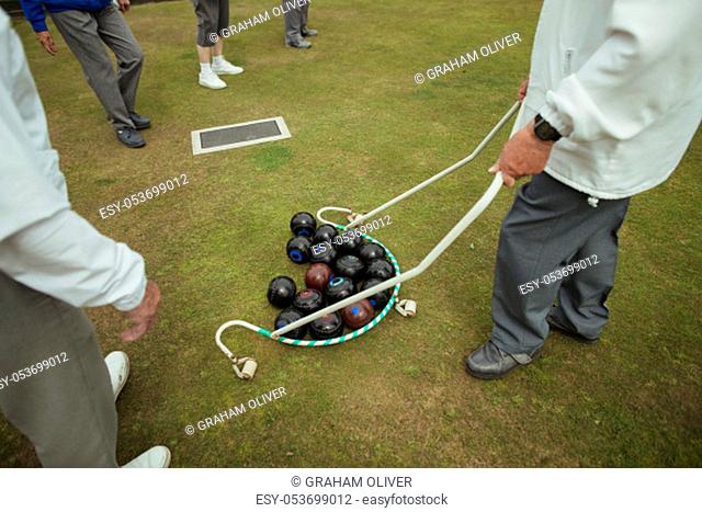 A group of bocce balls being collected by a pick up tool at a bowling green