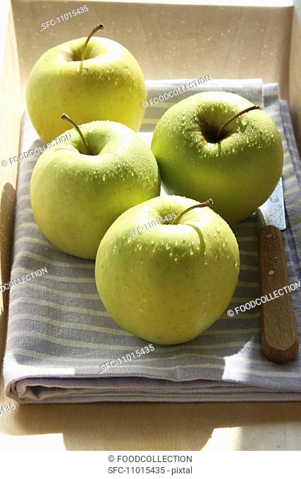 Apples on a tea towel with a knife