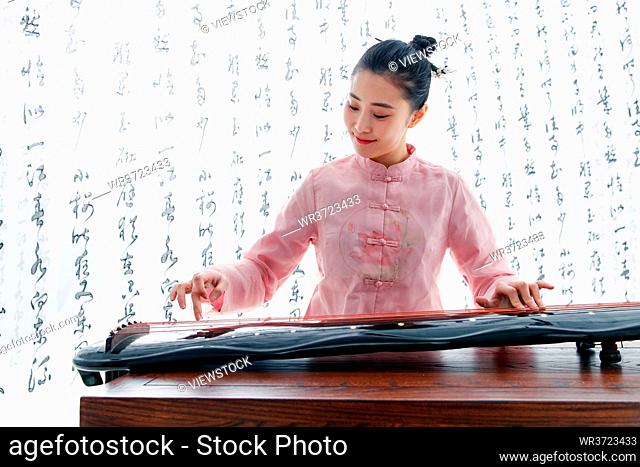 The young woman playing the guzheng
