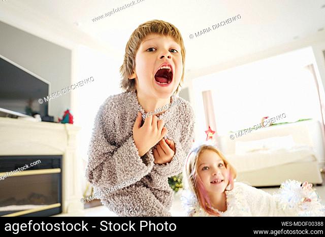 Boy screaming with sister in bedroom at home