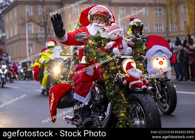 10 December 2022, Berlin: A participant in the ""Santa Claus on Road"" campaign rides through the city on a motorcycle decorated for Christmas