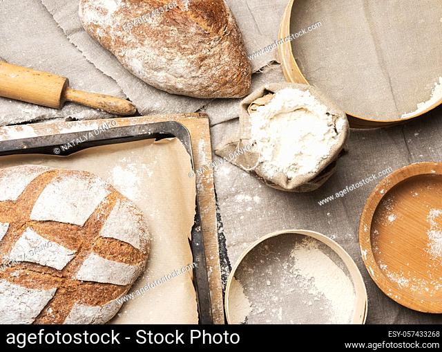 bread and white wheat flour in a bag, wooden rock and plate, top view
