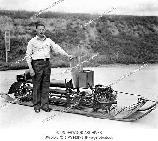 Sayner, Wisconsin: 1932.Carl J. Eliason, inventor and manufacturer of the first successful snowmobile, proudly stands beside one of his early snow machines