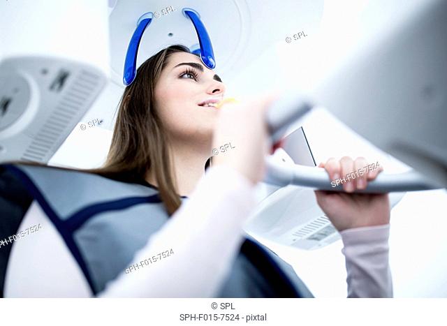 MODEL RELEASED. Young woman having dental x-ray in clinic
