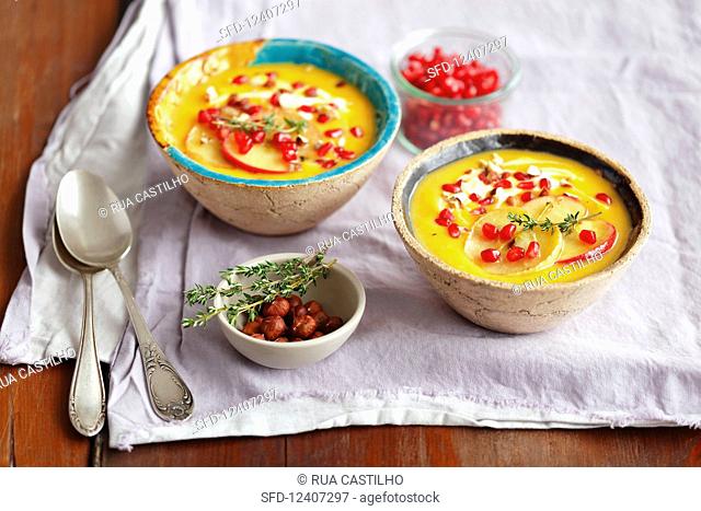 Pumpkin and sweet potatoes cream soup with apples and pomegranate