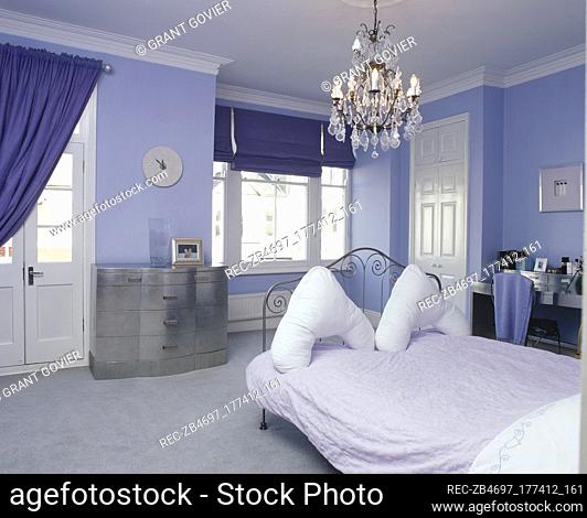 Blue bedroom with wrought iron bed and chandelier