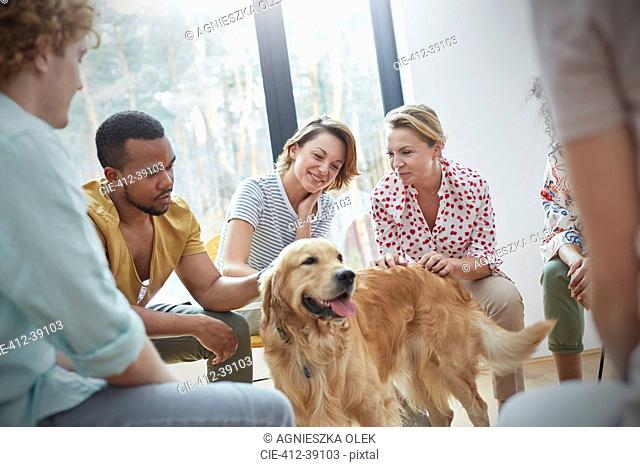 People petting dog in group therapy session