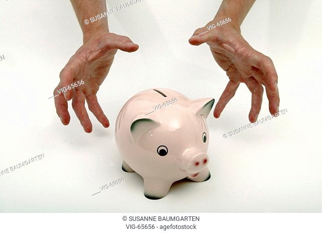 Hands reaching for a piggy bank. - 22/06/2004