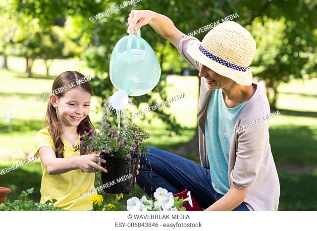Happy blonde and her daughter gardening