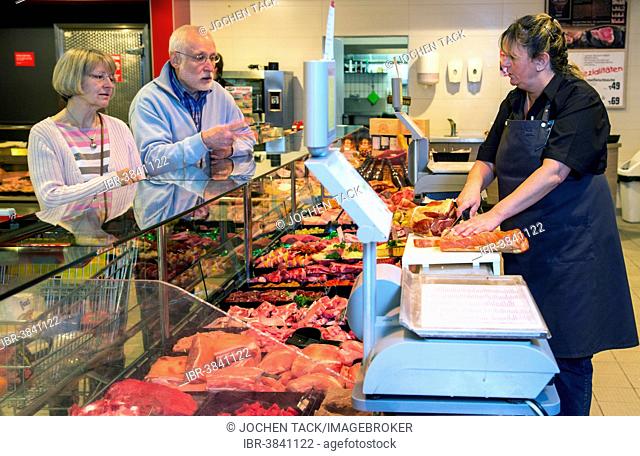 Senior couple shopping at the meat counter in the supermarket, Germany