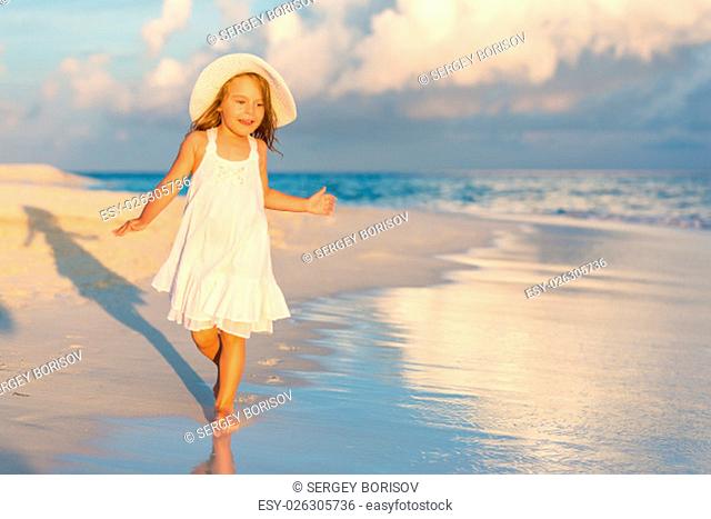 Little girl walking on beautiful ocean beach