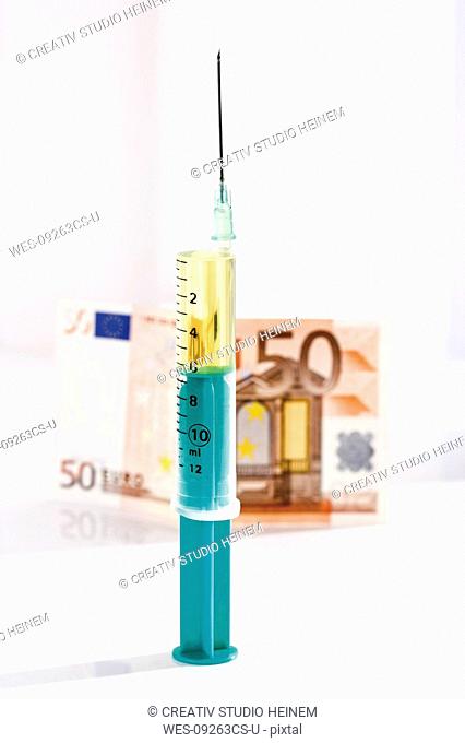 Syringe and Euro note, close-up
