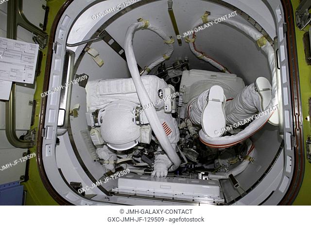 Astronauts Daniel W. Bursch (left) and Carl E. Walz are photographed in the crew lock of Quest prior to the February 20 space walk